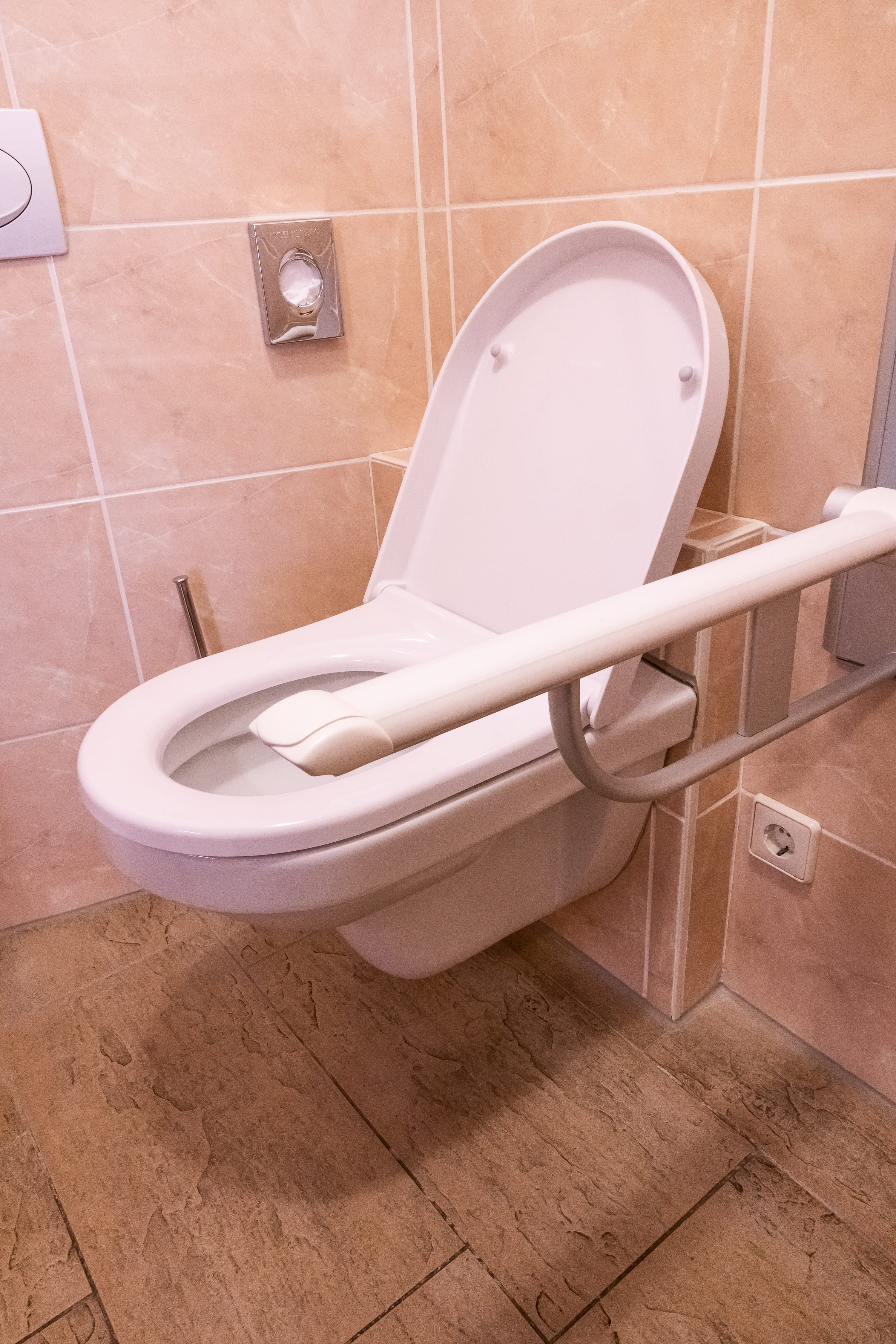Toilette mit ausklappbarer Armlehne