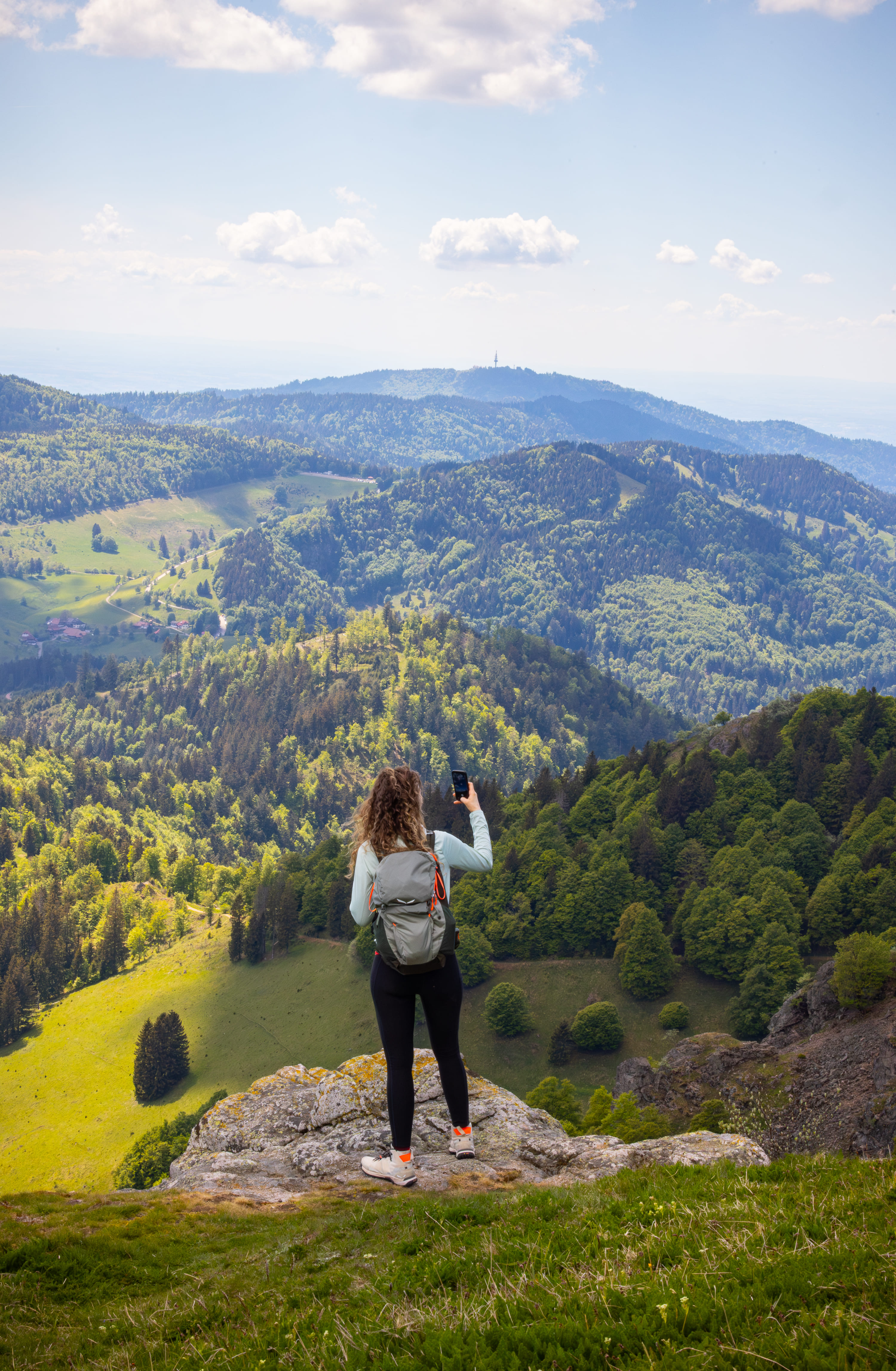 Auf dem Belchensteig. Frau macht mit ihrem Handy ein Foto vom Ausblick.
